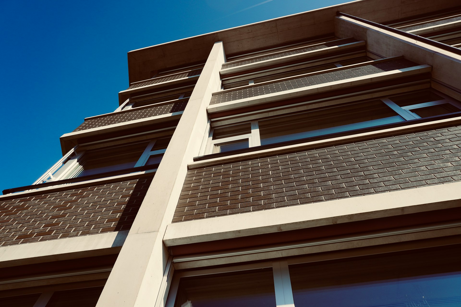 a tall building with windows and a sky background